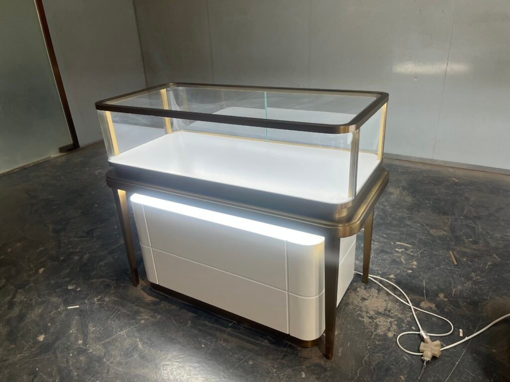 This is a display cabinet with glass windows and built - in lighting. It can be used to display precious items such as jewelry, ornaments and fine products. It combines the functions of display and protection, enhancing the texture of the products and the viewing experience.